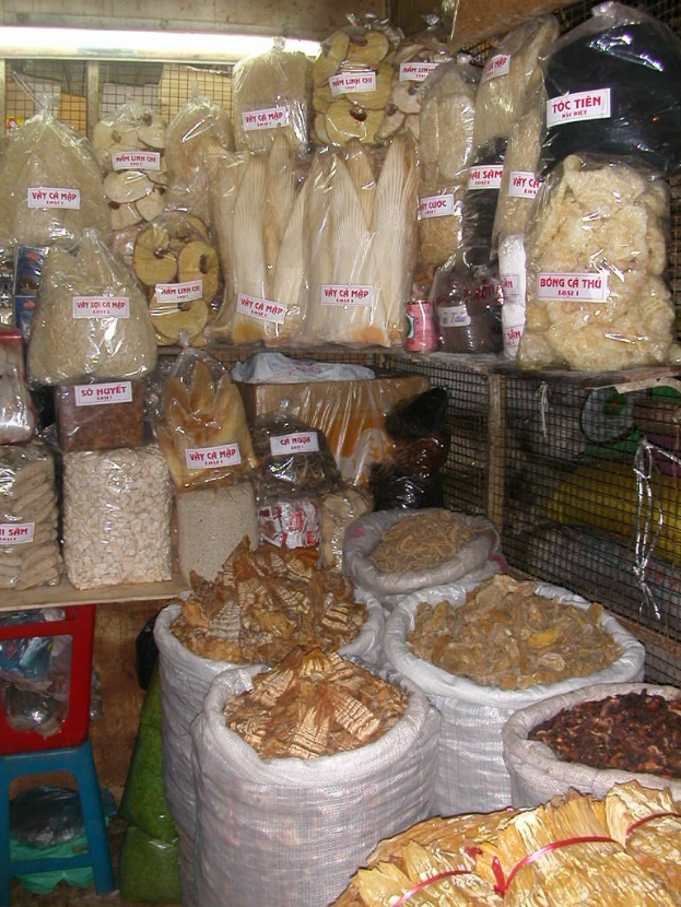 Ein Marktstand mit ordentlich sortierten Lebensmitteln in Tüten und Plastikabdeckungen, einschließlich anderer Gegenstände, die auf einen gut sortierten und organisierten Laden hinweisen.