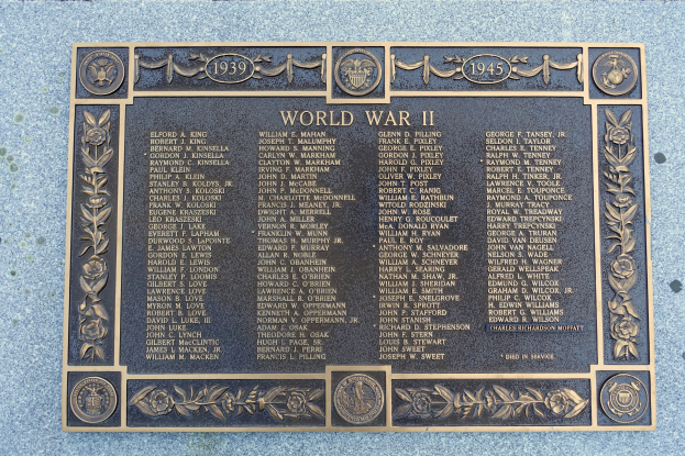 Steintafel an einer Gebäudeseite mit 'Zweiter Weltkrieg' eingraviert.