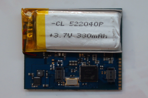 Nahaufnahme einer Handy-Batterie mit gedrucktem Text auf einer weißen Oberfläche über einer Leiterplatte.