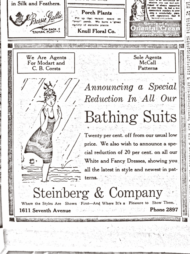 Eine Frau in einem weißen hochgeschlossenen, langärmeligen Kleid mit einem Dutt, die in der Mitte einer Steinberg & Company-Badeanzugwerbung steht, die Augen geschlossen und entspannt wirkend.