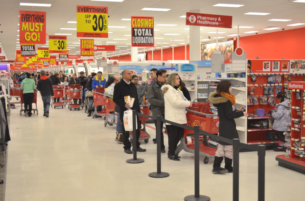 Ein überfüllter Walmart-Laden mit Einkaufswagen und Kunden, umgeben von Warenpräsentationen, Schildern und Deckenleuchten.