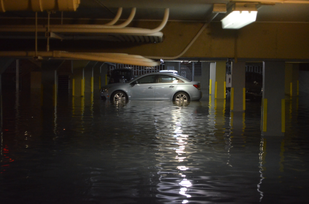Ein Auto in einer nächtlichen überfluteten Parkgarage unter Wasser