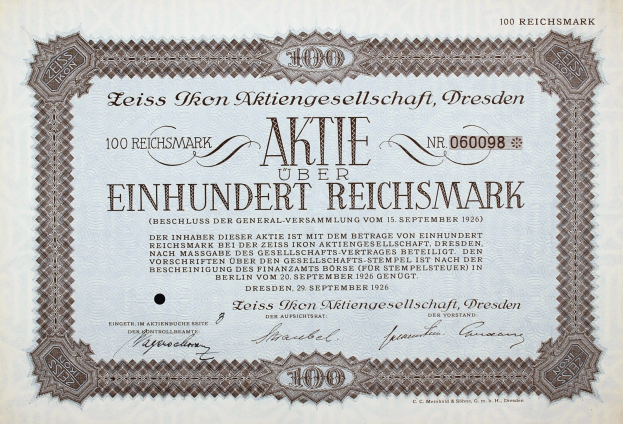 Alter deutscher Aktienchein für 100 Reichsmark mit schwarzem Rand und deutscher Text.