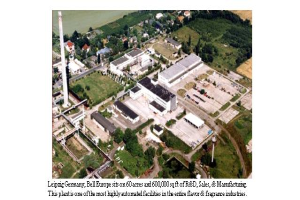 Eine Luftaufnahme eines Industriegebiets in Leipzig, Deutschland, mit Gebäuden, Grünflächen, Straßen und Masten sowie der Inschrift "Leipzig Germany - Bell Europe" unten.