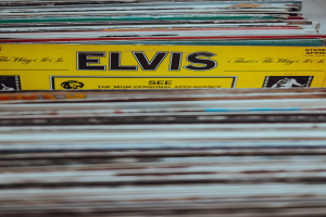 Stapel von Elvis-Presley-Platten, ordentlich übereinander gestapelt auf einem Tisch mit sichtbaren Titeln und leicht unscharfem Hintergrund.