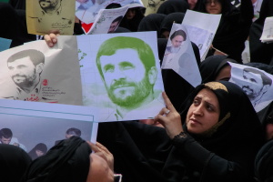 Eine Gruppe iranischer Frauen in schwarzer Kleidung hält Bilder des Präsidenten Mahmoud Ahmadinejad während einer Kundgebung in Tehran hoch.