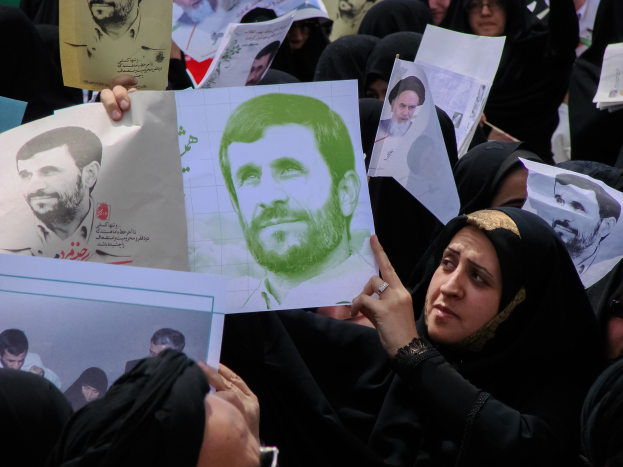 Eine Gruppe iranischer Frauen in schwarzer Kleidung hält Bilder des Präsidenten Mahmoud Ahmadinejad während einer Kundgebung in Tehran hoch.